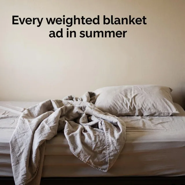 A rumpled beige linen blanket kicked half off a bed beside a pillow, with the headline text ‘Every weighted blanket ad in summer’ set above it on the plain wall.